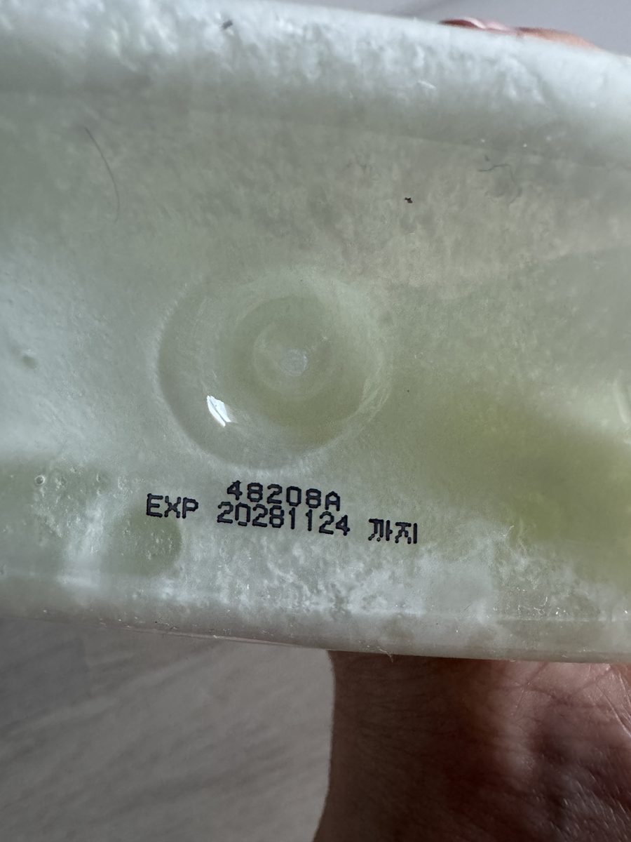 韓國洗髮精瓶底的噴印特寫，上排是批號 48208A，下排是 EXP 20281124 까지。